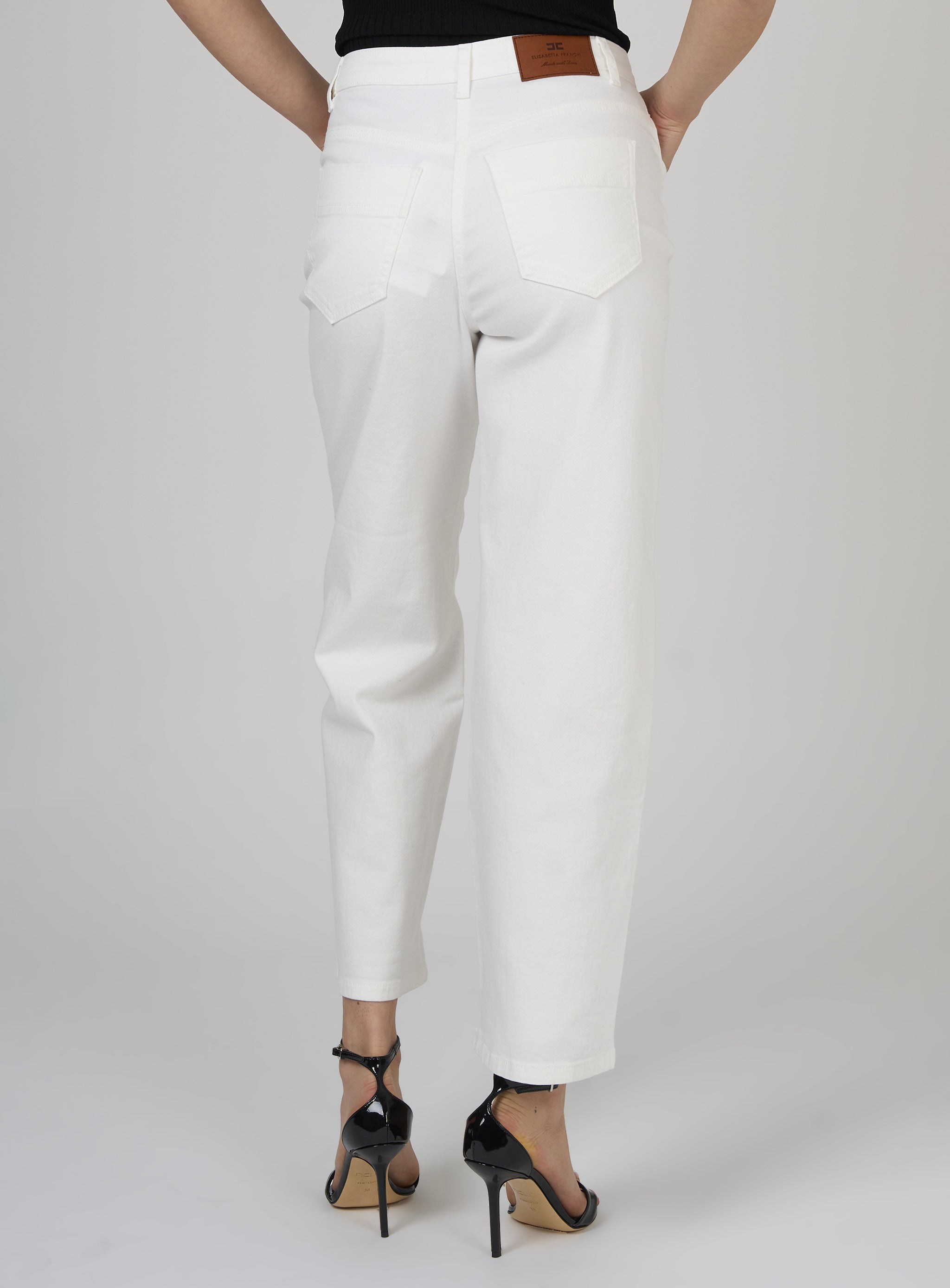 Jeans in cotone tinto con charm logato Bianco